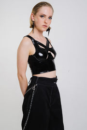 Seductive black vinyl top with cross over straps and a cropped fit.
